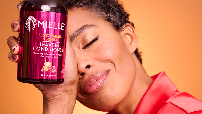 woman with short textured hair holding Mielle Leave-in Conditioner